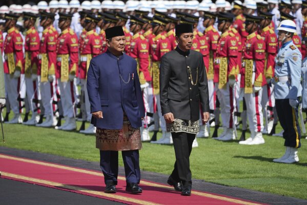 Indonesia's newly-inaugurated President Prabowo Subianto, left, and his predecessor Joko Widodo inspect honor guards during their handover ceremony at Merdeka Palace in Jakarta, Indonesia, Sunday, Oct. 20, 2024. (AP Photo/Achmad Ibrahim)