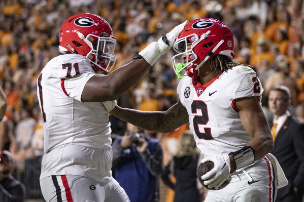 Georgia running back Kendall Milton (2) is congratulated by offensive lineman Earnest Greene III (71) after scoring a touchdown during the second half of an NCAA college football game against Tennessee, Saturday, Nov. 18, 2023, in Knoxville, Tenn. (AP Photo/Wade Payne)