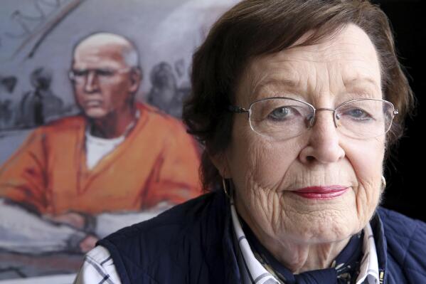 FILE - In this March 22, 2018, file photo, artist Jane Flavell Collins poses for a portrait at her home in Duxbury, Mass, with her sketch of Boston gangster Whitey Bulger appearing during his trial. Collins, a courtroom sketch artist who drew pictures of defendants in some of the most notorious cases tried in federal court in Boston, died Sunday, May 16 2021, according to her family. She was 84. (Craig F. Walker/The Boston Globe via AP, File)