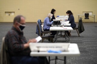 FILE - Workers prepare mail-in ballots for counting, Nov. 4, 2020, at the convention center in Lancaster, Pa. (AP Photo/Julio Cortez, File)