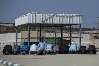 In this March 26, 2017 file photo, Palestinian residents of Gaza strip pray as they wait on the Israeli side of the Erez terminal to cross to Gaza Strip. (AP Photo/Tsafrir Abayov, File)
