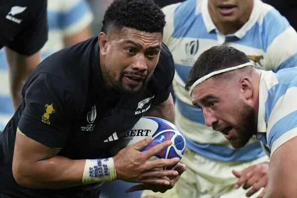 FILE - New Zealand's Ardie Savea, left, gets past Argentina's Eduardo Bello during the Rugby World Cup semifinal match at the Stade de France in Saint-Denis, outside Paris, on Oct 20, 2023. World Rugby Player of the Year Ardie Savea has tentatively endorsed a suggested policy change which would allow players based outside New Zealand to be considered for All Blacks selection. (AP Photo/Christophe Ena, File)