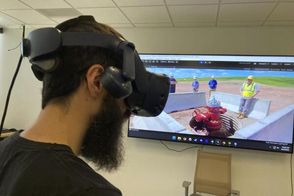 University of Wyoming School of Energy Resources 3D Visualization Manager Kyle Summerfield demonstrates virtual reality technology Aug. 10, 2022, in Laramie, Wyo. Virtual reality can help scientists and others study computer simulations of storing carbon dioxide underground in northeastern Wyoming. New federal tax credits and billions of dollars in new funding are likely to boost such efforts to counter climate change. (AP Photo/Mead Gruver)