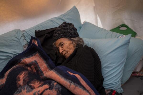 An elderly woman from the Teke family lies inside a tent at a camp for earthquake displaced people in Kahramanmaras, Turkey, Friday, Feb. 17, 2023. A 7.8 magnitude earthquake with its epicenter in Turkey's southeastern Kharamanmaras province struck in the early hours of Feb. 6, followed by multiple aftershocks, including a major one magnitude 7.5 nine hours after the first tremor. (AP Photo/Bernat Armangue)
