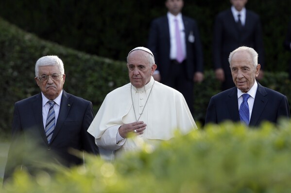 FILE - Pope Francis is flanked by Israel's President Shimon Peres, right, and Palestinian President Mahmoud Abbas during an evening of peace prayers in the Vatican gardens, Sunday, June 8, 2014. Pope Francis gathered the Israeli and Palestinian ambassadors to the Vatican Gardens on Friday, June 7, 2024 to pray for an end to the war in Gaza, marking the 10th anniversary of a similar encounter with the Israeli and Palestinian presidents with a new appeal for peace.(AP Photo/Gregorio Borgia, File)