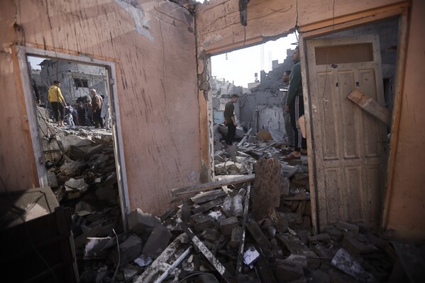 Palestinians look at destruction after the Israeli bombing In Khan Younis refugee camp in Gaza Strip on Friday, Dec. 1, 2023. (AP Photo/Mohammed Dahman)