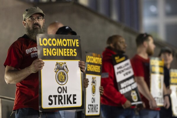 Union members from the Brotherhood of Locomotive Engineers and Trainmen form a picket line outside the NJ Transit Headquarters on Friday, May 16, 2025 in Newark, New Jersey. (AP Photo/Stefan Jeremiah)