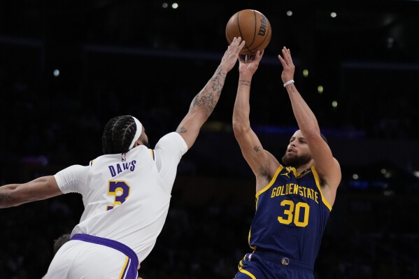 Golden State Warriors guard Stephen Curry (30) shoots against Los Angeles Lakers forward Anthony Davis (3) during the first half of an NBA basketball game in Los Angeles, Saturday, March 16, 2024. (AP Photo/Ashley Landis)