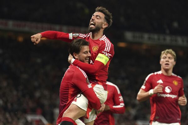 Manchester United's Mason Mount, left, celebrates with Bruno Fernandes after scoring their first goal of the game during the Europa League semifinal second leg soccer match between Manchester United and Athletic Bilbao in Manchester, Britain, Thursday, May 8, 2025. (Martin Rickett/PA via AP)
