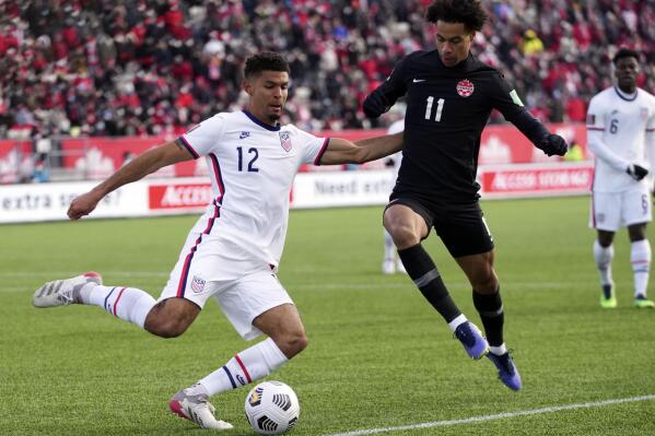 File - Canada's Tajon Buchanan, right, pressures United States' Miles Robinson during the first half of a World Cup soccer qualifier in Hamilton, Ontario,  Jan. 30, 2022. Atlanta United defender Robinson will likely miss the World Cup for the United States after rupturing the Achilles tendon in his left leg during an MLS game. (Nathan Denette/The Canadian Press via AP, File)
