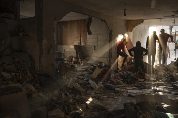 Palestinians check a house destroyed in the Israeli bombardment on Rafah, Gaza Strip, Thursday, Dec. 7, 2023. (AP Photo/Fatima Shbair)