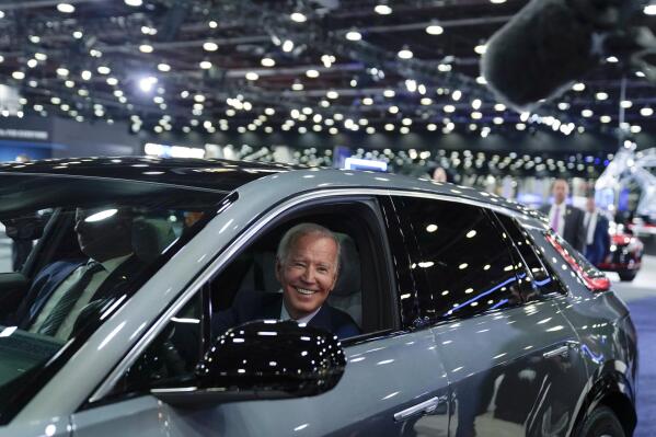 FILE - President Joe Biden drives a Cadillac Lyriq through the showroom during a tour at the Detroit Auto Show, Sept. 14, 2022, in Detroit. Ratcheting up his criticism of the Biden administration, Democratic Sen. Joe Manchin introduced legislation Wednesday to delay new tax credits for electric vehicles, a key feature of President Joe Biden’s landmark climate law. Manchin said guidelines issued by the Treasury Department allow manufacturers in Europe and other countries to bypass requirements that significant portions of EV batteries must be produced in North America. (AP Photo/Evan Vucci, File)