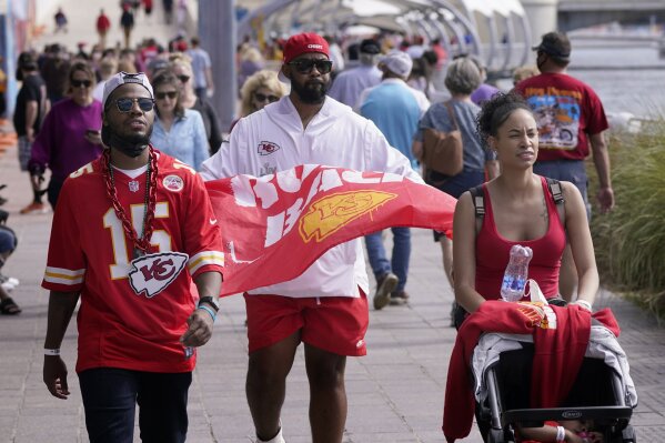 FILE - In this Feb. 5, 2021, file photo, people walk down a sidewalk near Super Bowl 55 activities in Tampa, Fla. The city is hosting Sunday's Super Bowl football game between the Tampa Bay Buccaneers and the Kansas City Chiefs. (AP Photo/Charlie Riedel, File)