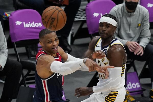 Washington Wizards guard Russell Westbrook (4) passes the ball as he is guarded by Indiana Pacers guard Aaron Holiday (3) during the second half of a basketball game, Monday, May 3, 2021, in Washington. (AP Photo/Alex Brandon)