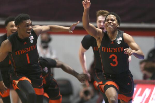 Miami's Charlie Moore (3) right, celebrates with Anthony Walker (1) left, and Sam Waardenburg (21) after making the winning shot at the buzzer to end second half of an NCAA college basketball game against Virginia Tech, Wednesday, Jan. 26 2022, in Blacksburg Va. (Matt Gentry/The Roanoke Times via AP)