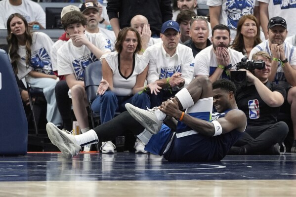Minnesota Timberwolves guard Anthony Edwards (5) grabs his leg during the first half of Game 2 of an NBA basketball second-round playoff series against the Golden State Warriors, Thursday, May 8, 2025, in Minneapolis. (AP Photo/Abbie Parr)