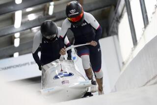 FILE - In this Feb. 5, 2021, file photo, Kaillie Humphries and Lolo Jones, of the United States, start during the two-women's bobsled race at the Bobsled and Skeleton World Championships in Altenberg, Germany.  Reigning women’s world bobsled champion and three-time Olympic medalist Humphries has asked the International Olympic Committee for a solution that would allow her to compete in this winter’s Beijing Games even though her American citizenship will not be finalized. (AP Photo/Matthias Schrader, File)