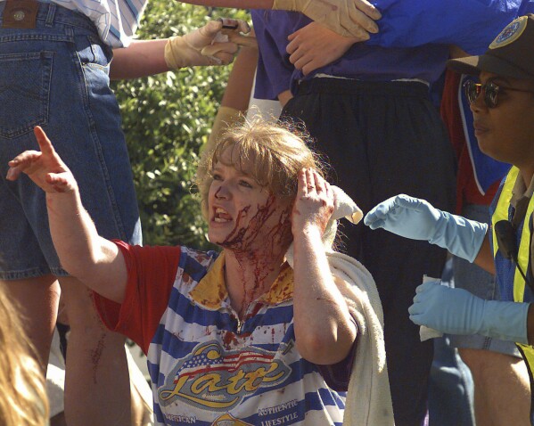 An unidentified woman calls out to friends as she waits for treatment following a bomb blast at the Alfred P. Murrah Federal Building in downtown Oklahoma City, April 19, 1995. (AP Photo/David Longstreath, File)