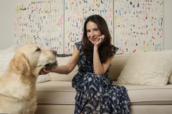 Author Allison Winn Scotch is joined by her dog Mr. Peanut as she poses for a portrait at home, Monday, Feb. 26, 2024, in Los Angeles. (AP Photo/Chris Pizzello)
