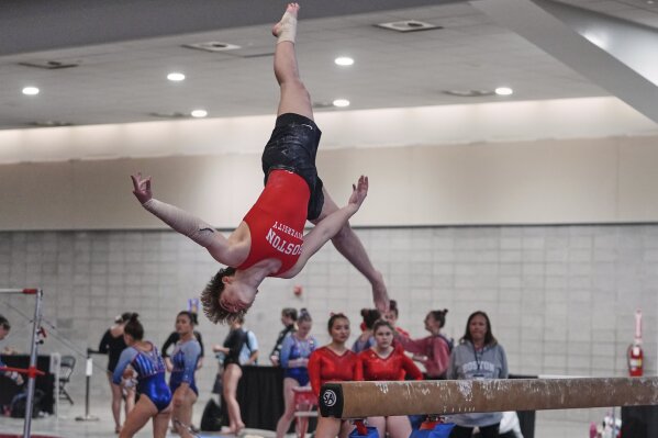 Ten Harder of Boston University Gymnastics Club in Boston, dismounts the balance beam at the 2025 NAIGC national competition in Pittsburgh, Friday, April 4, 2025. (AP Photo/Gene J. Puskar)