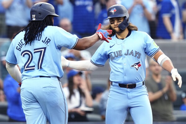 Toronto Blue Jays' Bo Bichette, right, celebrates his two-run home run against the Chicago White Sox with Vladimir Guerrero Jr. (27) during the second inning of a baseball game Wednesday, May 22, 2024, in Toronto. (Frank Gunn/The Canadian Press via AP)