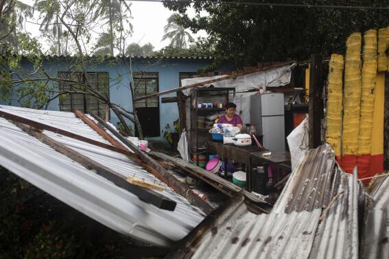 A woman begins clearing debris from her kitchen after a part of her home was damaged by winds brought on by Hurricane Grace, in Tecolutla, Veracruz State, Mexico, Saturday, Aug. 21, 2021. Grace hit Mexico’s Gulf shore as a major Category 3 storm before weakening on Saturday, drenching coastal and inland areas in its second landfall in the country in two days. (AP Photo/Felix Marquez)