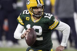 FILE - In this Jan. 16, 2021, file photo, Green Bay Packers quarterback Aaron Rodgers (12) runs during an NFL divisional playoff football game against the Los Angeles Rams in Green Bay, Wis. Packers general manager Brian Gutekunst says the team remains committed to Rodgers “for the foreseeable future” one year after trading up in the first round to draft the three-time MVP’s potential successor. (AP Photo/Jeffrey Phelps, File)