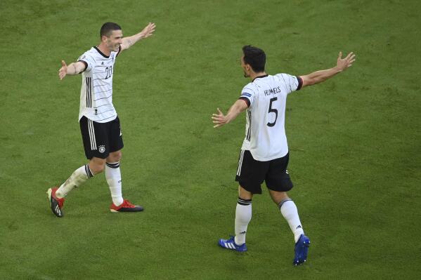 Germany's Robin Gosens, left, celebrates Germany's Mats Hummels after scoring his side's fourth goal during the Euro 2020 soccer championship group F match between Portugal and Germany at the football arena stadium in Munich, Saturday, June 19, 2021. (Matthias Hangst/Pool Photo via AP)
