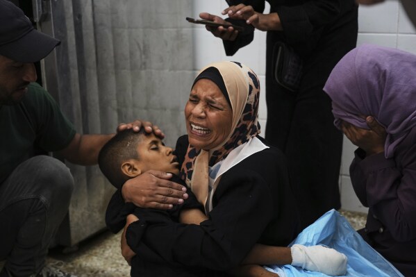 Sherine Abu Mor, embraces the body of her son, Hamza Al-Shaer, who was killed in an Israeli army airstrike, at the Al-Aqsa Hospital in Deir al-Balah, Gaza Strip, Saturday, June 14, 2025. (AP Photo/Abdel Kareem Hana)
