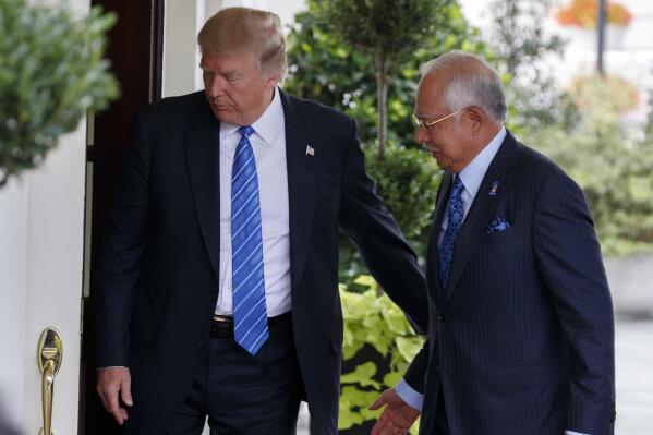 FILE - US President Donald Trump greets Malaysian Prime Minister Najib Razak at the White House, Sept. 12, 2017, in Washington. Najib Razak on Tuesday, Aug. 23, 2022 was Malaysia’s first former prime minister to go to prison -- a mighty fall for a veteran British-educated politician whose father and uncle were the country’s second and third prime ministers, respectively. The 1MDB financial scandal that brought him down was not just a personal blow but shook the stranglehold his United Malays National Organization party had over Malaysian politics.(AP Photo/Evan Vucci, file)