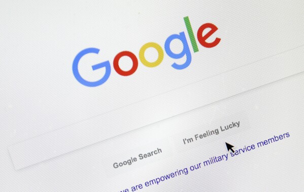 FILE - A cursor moves over Google's search engine page, Aug. 28, 2018, in Portland, Ore. On Tuesday, Sept. 26, 2023, a top Apple executive defended the tech giant’s decision to make Google the default search engine on Apple iPhones and Macs, saying there was no “valid alternative.’’ (AP Photo/Don Ryan, File)