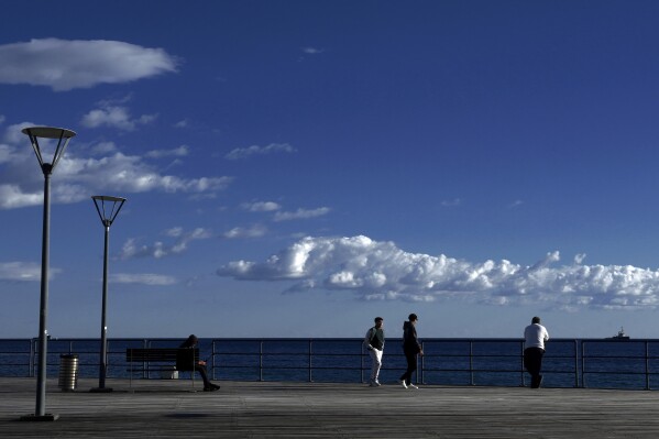 People enjoy the sun and the sea in the southern port city of Limassol on the eastern Mediterranean island of Cyprus, Saturday, Jan. 27, 2024. (AP Photo/Petros Karadjias)