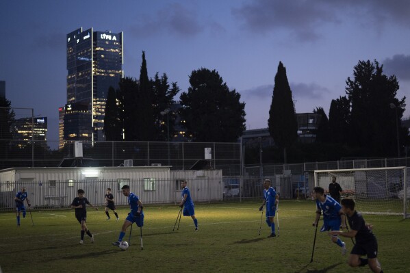Israel Amputee Football Team soccer players take part in a practice session with young players from a local team in Ramat Gan, Thursday, April 11, 2024. The team offers players the excitement of competition, an outlet for their energies and the healing powers of sport, of overcoming the mental and physical challenges of disability. (AP Photo/Leo Correa)