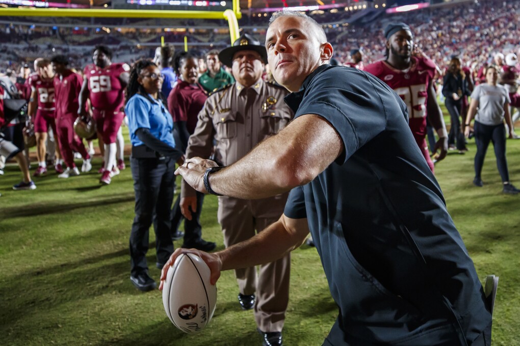 Florida State coach Mike Norvell throws an autographed football to fans in the stands after the team's NCAA college football game against North Alabama, Saturday, Nov. 18, 2023, in Tallahassee, Fla. (APPhoto/Colin Hackley)