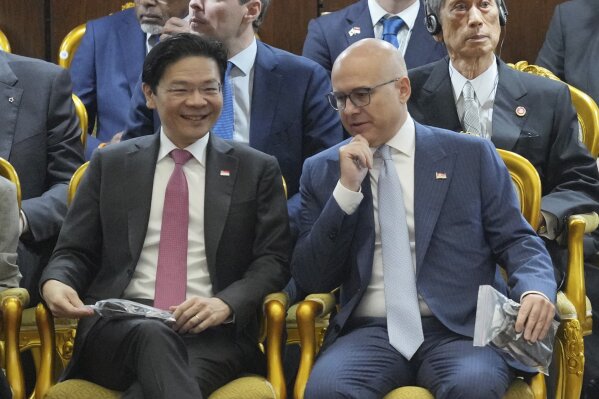 Singaporean Prime Minister Lawrence Wong, left, talks with his Serbian counterpart Milos Vucevic, as they attend the swearing in ceremony of Indonesia's new President Prabowo Subianto at the parliament building in Jakarta, Indonesia, Sunday, Oct. 20, 2024. (AP Photo/Tatan Syuflana)