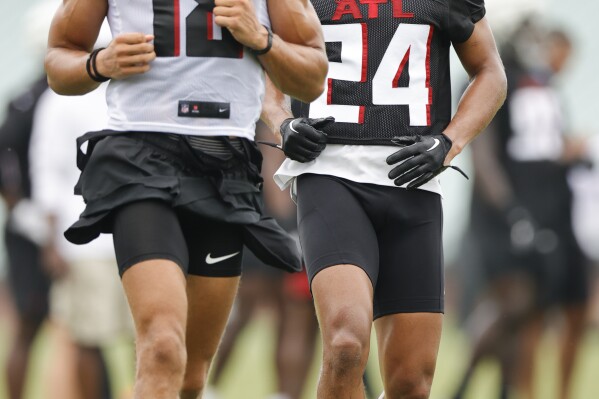 Atlanta Falcons wide receiver Mack Hollins, left, and cornerback A.J. Terrell, right, run a drill during the NFL football team's training camp, Saturday, July 29, 2023, in Flowery Branch, Ga. (AP Photo/Alex Slitz)