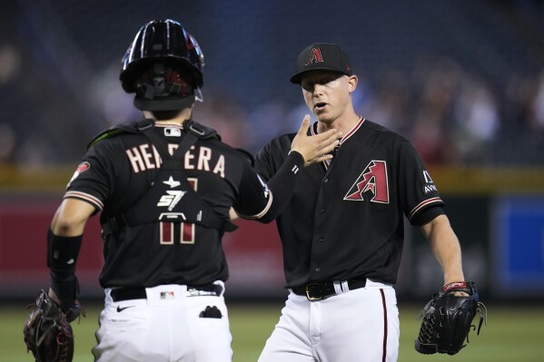 Arizona Diamondbacks relief pitcher Scott McGough, right, celebrates the final out against the Colorado Rockies with Diamondbacks catcher Jose Herrera in the ninth inning of a baseball game Wednesday, Sept. 6, 2023, in Phoenix. The Diamondbacks won 12-5. (AP Photo/Ross D. Franklin)