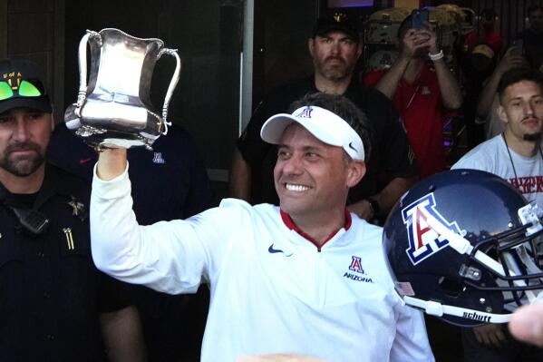 Arizona coach Jedd Fisch holds up the Territorial Cup after the team's 38-35 win over Arizona during an NCAA college football game Friday, Nov. 25, 2022, in Tucson, Ariz. (AP Photo/Rick Scuteri)
