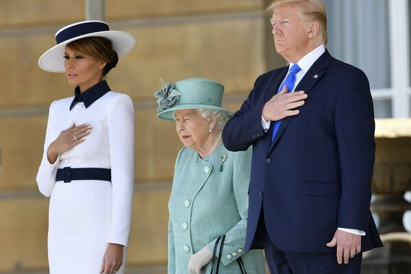 US President Donald Trump and first lady Melania Trump attend a welcome ceremony with Britain's Queen Elizabeth II in the garden of Buckingham Palace, in London, for Monday June 3, 2019, on the first day of a three day state visit to Britain. (Toby Melville/Pool via AP)