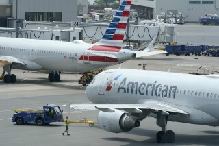 FILE - American Airlines passenger jets prepare for departure, July 21, 2021, near a terminal at Boston Logan International Airport in Boston. (AP Photo/Steven Senne, File)