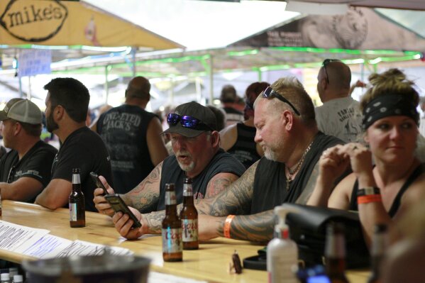 People congregates at One-Eyed Jack's Saloon during the 80th annual Sturgis Motorcycle Rally on Aug. 7, 2020, in Sturgis, South Dakota. The South Dakota Department of Health issued warnings that two people who had visited the bar may have transmitted COVID-19. (AP Photo/Stephen Groves)