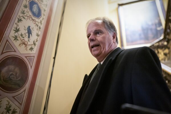 FILE - In this Jan. 31, 2020 file photo, Sen. Doug Jones, D-Ala., is questioned by reporters as he arrives at the Capitol for the impeachment trial of President Donald Trump on charges of abuse of power and obstruction of Congress, in Washington.   Jones, the most endangered Democrat in this November's elections, said Wednesday that he will vote to convict President Donald Trump Wednesday as the Senate impeachment trial reaches its climax. (AP Photo/J. Scott Applewhite)