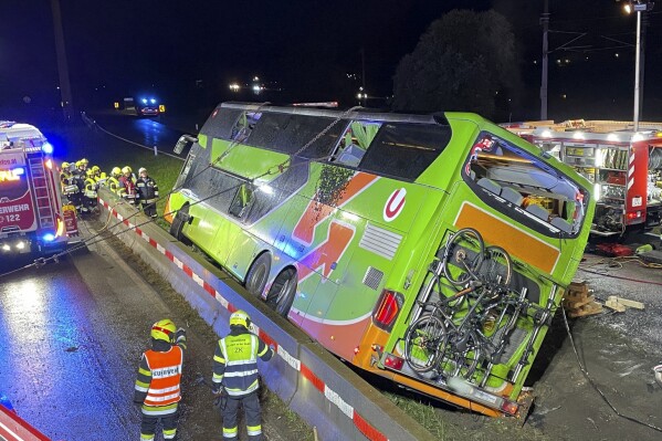 General view of the scene of a bus accident in Micheldorf, Austria, early Tuesday, Sept. 19, 2023. A bus coach traveling through Austria has driven off the road and crashed on its side, killing a woman and injuring 20 other passengers. Austrian broadcaster ORF reported the accident took place Tuesday near the village of Micheldorf in Carinthia state in central Austria. (FF-Althofen.AT via AP)
