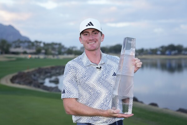 Nick Dunlap holds the trophy after winning the American Express golf tournament, Sunday, Jan. 21, 2024, in La Quinta, Calif. (AP Photo/Ryan Sun)