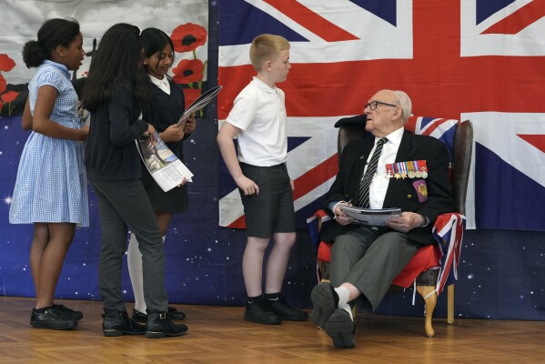 D-Day veteran and Ambassador for the British Normandy Memorial, Ken Hay, 98, who served with the 4th Dorset Regiment, speaks to children during a visit to Rush Green Primary School in Dagenham, England, Monday May 20, 2024, ahead of the 80th anniversary of the D-Day landings. (Gareth Fuller/PA via AP)
