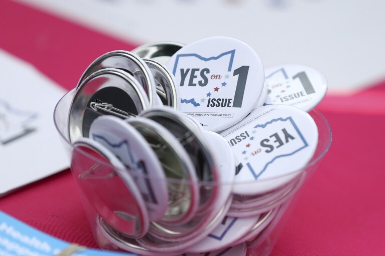 FILE - Buttons in support of Issue 1, the Right to Reproductive Freedom amendment, sit on display at a rally held by Ohioans United for Reproductive Rights at the Ohio Statehouse in Columbus, Ohio, Oct. 8, 2023. As campaigning escalates in Ohio's fall fight over abortion rights, a new line of attack from opponents suggests "partial-birth" abortions would be revived if a proposed constitutional amendment passes. (AP Photo/Joe Maiorana, File)