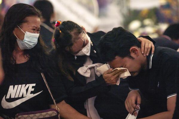 Relatives console Seksan Sriraj, 28, who lost his pregnant wife in a mass killing attack, at Wat Rat Samakee temple in Uthai Sawan, north eastern Thailand, Saturday., Oct. 8, 2022. A former police officer burst into a day care center in northeastern Thailand on Thursday, killing dozens of preschoolers and teachers before shooting more people as he fled. (AP Photo/Wason Wanichakorn)