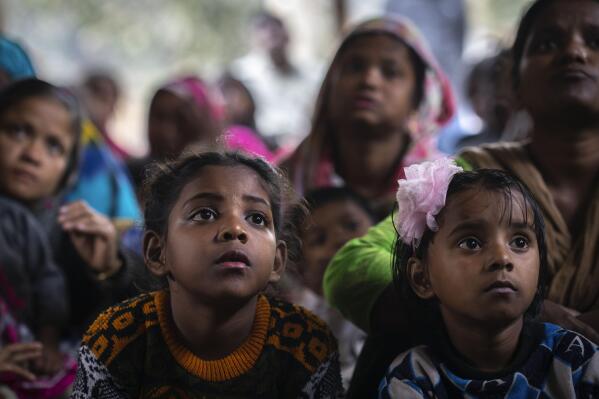 Girls with their mothers listen to a non-governmental organization worker during an awareness camp about child marriage, in a shanty town in Guwahati, India, Friday, Feb. 10, 2023. In India, the legal marriageable age is 21 for men and 18 for women. Poverty, lack of education, and social norms and practices, particularly in rural areas, are considered reasons for child marriages across the country. UNICEF estimates that at least 1.5 million girls under 18 get married in India every year, making it home to the largest number of child brides in the world, accounting for a third of the global total. (AP Photo/Anupam Nath)