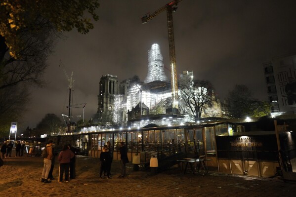Notre-Dame de Paris cathedral is seen with its spire surrounded by scaffolding Tuesday, Dec. 5, 2023 in Paris. The restoration of Notre Dame hits a milestone Friday, Dec. 8, 2023: one year until the cathedral reopens its huge doors to the public. (APPhoto/Thibault Camus)