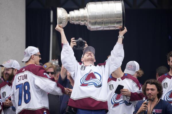 Colorado Avalanche defenseman Josh Manson lifts the Stanley Cup during a rally outside the City/County Building for the NHL hockey champions after a parade through the streets of downtown Denver, Thursday, June 30, 2022. (AP Photo/David Zalubowski)